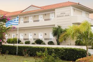 卡拉马孔扎金索斯岛卡拉马基海滩酒店的前面有旗帜的建筑