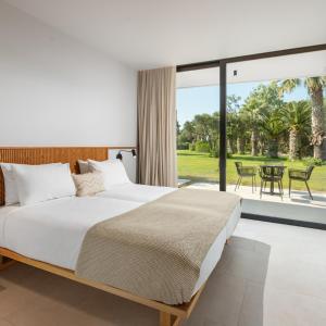 马尔马里卡拉维尔海滩酒店的一间带大床的卧室和一个露台