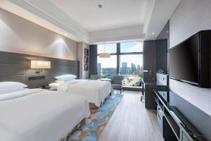 贵阳贵阳万丽酒店的酒店客房设有两张床和一台平面电视。
