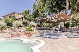 蒙泰卡蒂尼瓦尔迪切奇纳Villa Cedri的一个带游泳池、遮阳伞和椅子的庭院