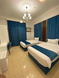阿哈达منتجع أرين للوحدات السكنية的酒店客房设有两张床和吊灯。