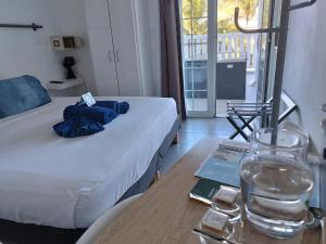 圣皮埃尔林赛酒店的一间设有一张床和一张桌子的房间,配有一杯水