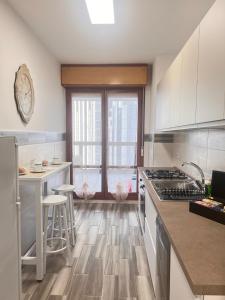 那不勒斯City Home 77的厨房铺有木地板,配有白色橱柜。