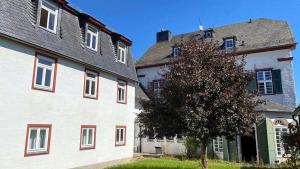 Kall施泰因费尔德修道院酒店的树旁有红色点缀的白色建筑