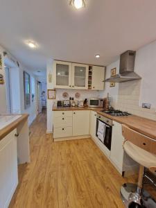 布里真德Town Cottage ground floor appartment的厨房铺有木地板,配有白色橱柜。