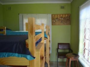 德班Mkhumbane Backpackers的一间卧室配有双层床和椅子