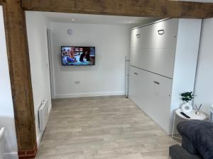 EastergateAcorn Lodge的带冰箱的厨房和墙上的电视