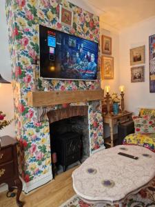 布里真德Town Cottage ground floor appartment的客厅设有壁炉,上面配有电视