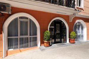 第比利斯Hotel Art Nikola Rooms的两个拱形入口,通往一座有两株盆栽植物的建筑