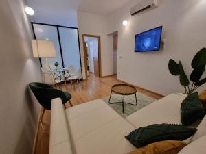 马德里Apartamentos San Isidro的客厅配有白色的沙发和桌子