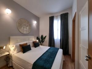 马德里Apartamentos San Isidro的卧室设有一张白色大床和一扇窗户。