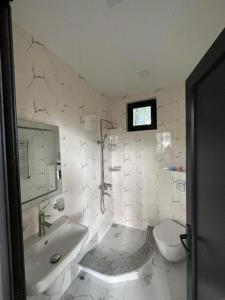 谢赫维蒂利Lilus Apartament Shekvetili的白色的浴室设有浴缸和卫生间。
