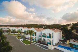 尼奥克瑞奥Latchi Escape Hotel and Suites - By IMH Travel & Tours的享有棕榈树成荫的大型白色建筑的景致。