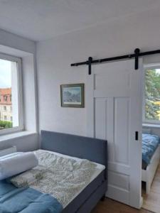 瓦尔米亚地区利兹巴克Apartament z Napoleonem w tle的一间卧室配有一张床,一扇门设有窗户