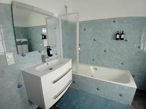 卡尔艾普卢盖VILLA CLARETTE的一间带水槽、浴缸和镜子的浴室