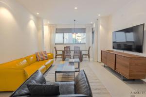 特拉维夫Luxury Shenkin 2BR by Airsuite的客厅设有黄色沙发和电视