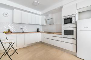阿里纳加Casa Daura Playa de Arinaga 2023 Reformed的白色的厨房配有白色橱柜和水槽