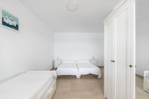 阿里纳加Casa Daura Playa de Arinaga 2023 Reformed的一间白色卧室,配有两张床和镜子