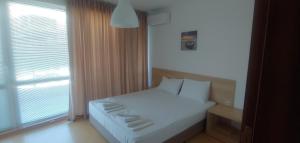 金沙Kabakum Apartments的卧室配有白色的床和窗户。