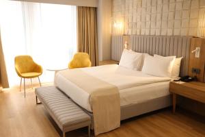 伊斯坦布尔Nova Plaza Prime Hotel的酒店客房带一张床、一张桌子和椅子