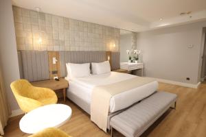 伊斯坦布尔Nova Plaza Prime Hotel的配有一张床和一把椅子的酒店客房