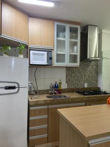 圣卡洛斯Apartamento Mari 4的厨房配有木制橱柜和白色冰箱。