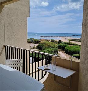 帕拉瓦莱弗洛Front de plage的阳台配有桌子,享有海滩美景