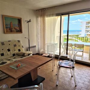 帕拉瓦莱弗洛Front de plage的客厅配有桌子,享有海景