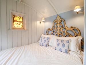 哈勒斯登Utopia的卧室配有白色床和蓝色及白色枕头