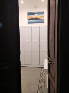 那不勒斯Chiarini22 Apartments的走廊上设有白色储物柜和墙上的绘画