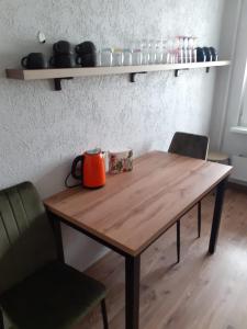 利耶帕亚Our Little World的一张带两把椅子的木桌旁的橙色茶壶