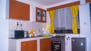 内罗毕One Bed Garden Estate Nairobi的厨房配有木制橱柜和炉灶烤箱。