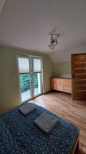 格雷德克纳德纳杰姆Domki Całoroczne Południowy Stok的一间卧室配有一张床、梳妆台和窗户。
