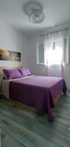 拉梅特拉·德·玛尔Mar Salada的卧室内的紫色床,带窗户