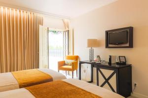 奥比多斯Josefa D`Obidos Hotel的酒店客房设有两张床和电视。