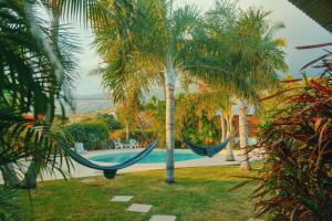 圣勒LES PECHEURS DU LAGON的游泳池旁两棵棕榈树之间的吊床