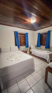 马拉戈日Village Miramar的一间卧室设有两张床和蓝色窗帘