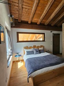 Roccaforte MondovìAi Tetti Nuovi的一间带一张大床的卧室,位于一个拥有木制天花板的房间