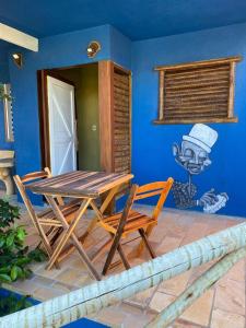 福廷Pousada Nascer da Lua的蓝色墙壁的房间里一张桌子和椅子