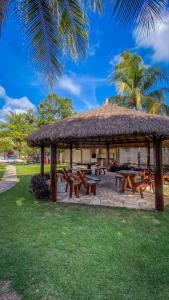 马拉戈日Village Miramar的一个带野餐桌和稻草屋顶的凉亭