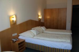 斯图加特Evangelische Diakonissenanstalt Stuttgart的一间卧室配有一张带木制床头板的床