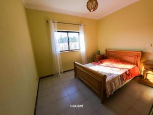 Casa Aveiro的一间卧室设有一张床和一个窗口