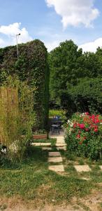 Détente champêtre, maisonnette rénovée en 2023的种满鲜花、桌子和长凳的花园