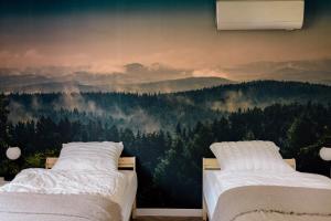 斯雷布纳古拉Apartamenty Koziołek的一间卧室设有两张床,并拥有森林壁画