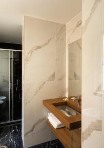 罗马内葛诺酒店的一间带水槽和大理石墙的浴室
