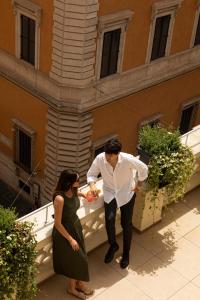 罗马内葛诺酒店的站在建筑物前面的男人和女人