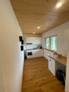 比登科普夫Ferienwohnung Biedenkopf的厨房铺有木地板,配有白色橱柜。