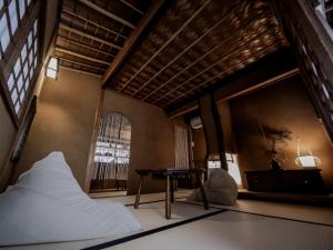 淡路古民家ゲストハウス CHACHACHA AWAJI的一间卧室配有一张床、一张桌子和一个窗户。