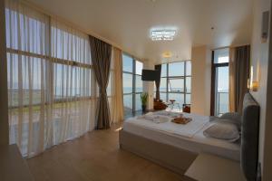 巴统RUMI Hotel的一间卧室设有一张大床和大窗户