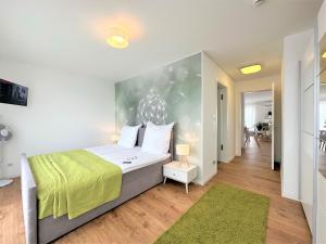 法兰肯塔尔Panorama Penthouse Apartment Whirlpool für 6 Personen的一间卧室配有一张带绿毯的大床